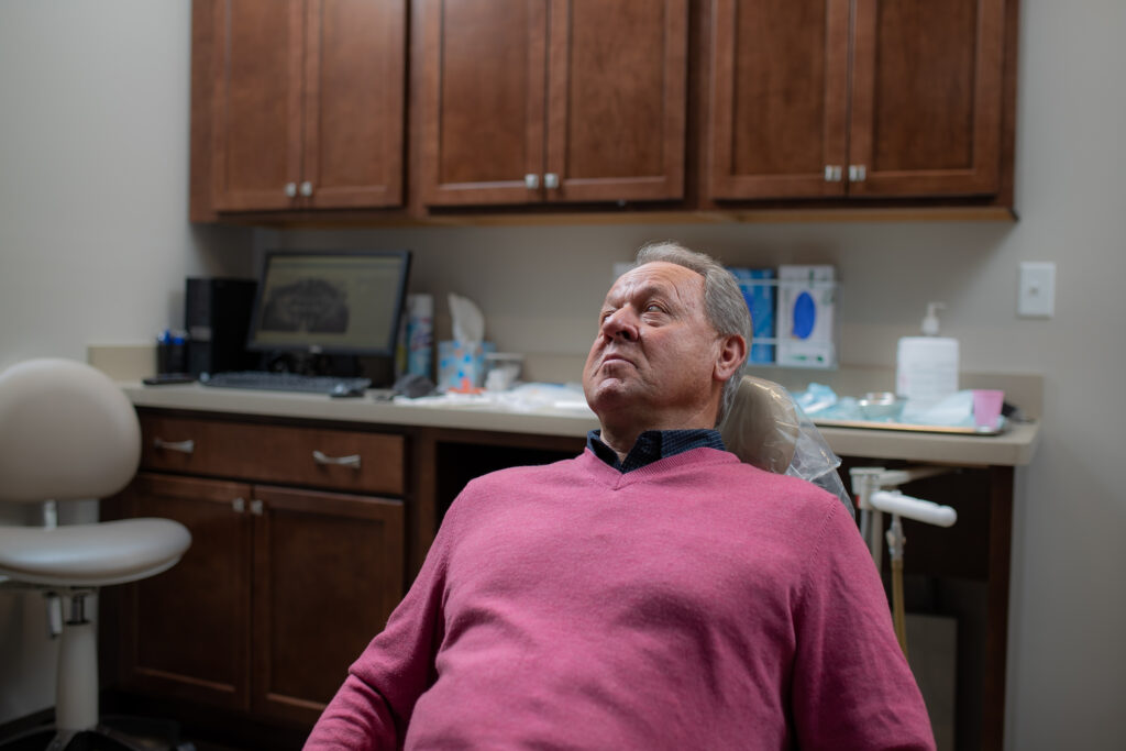 man sitting back in a dental chair at the oral surgery office