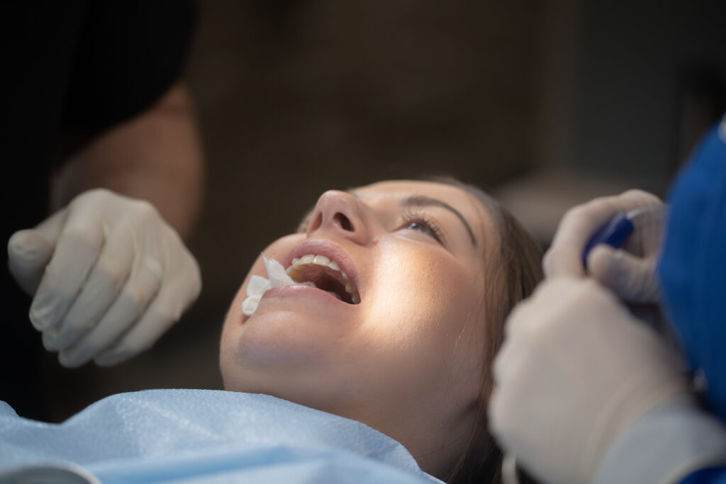 woman with her mouth open with surgical materials in her mouth