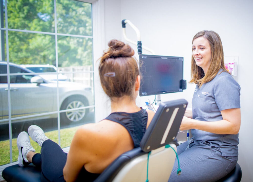 Doctor smiling at a patient sitting in a chair