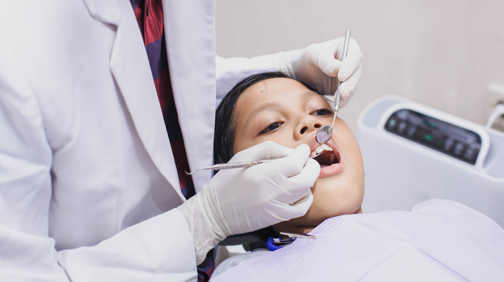 young boy getting his teeth examined for pediatric oral surgery